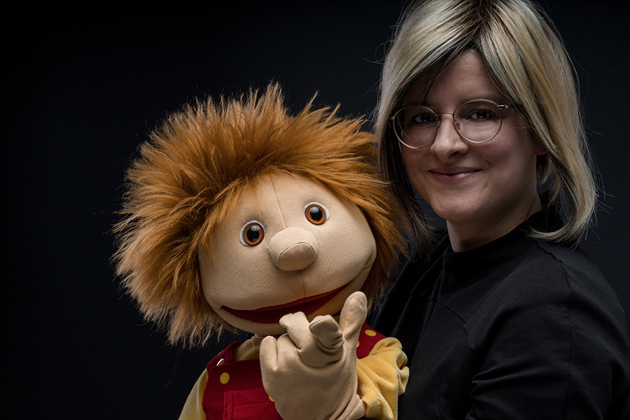 Eine Frau mit einer Puppe, die ihre Hand ausstreckt