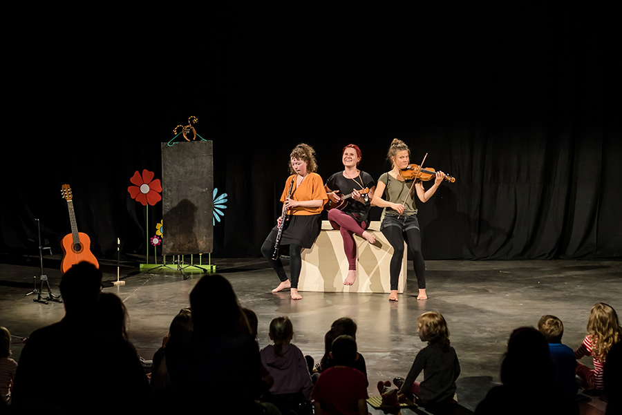 Drei Musikerinnen spielen vor Kinderpublikum
