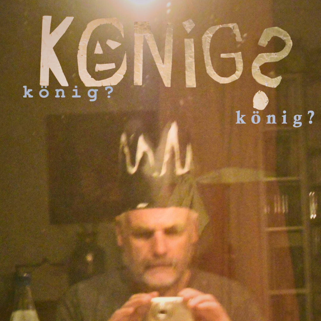 Ein Mann mit einer selbstgebastelten Krone, darüber der Schriftzug "König?"