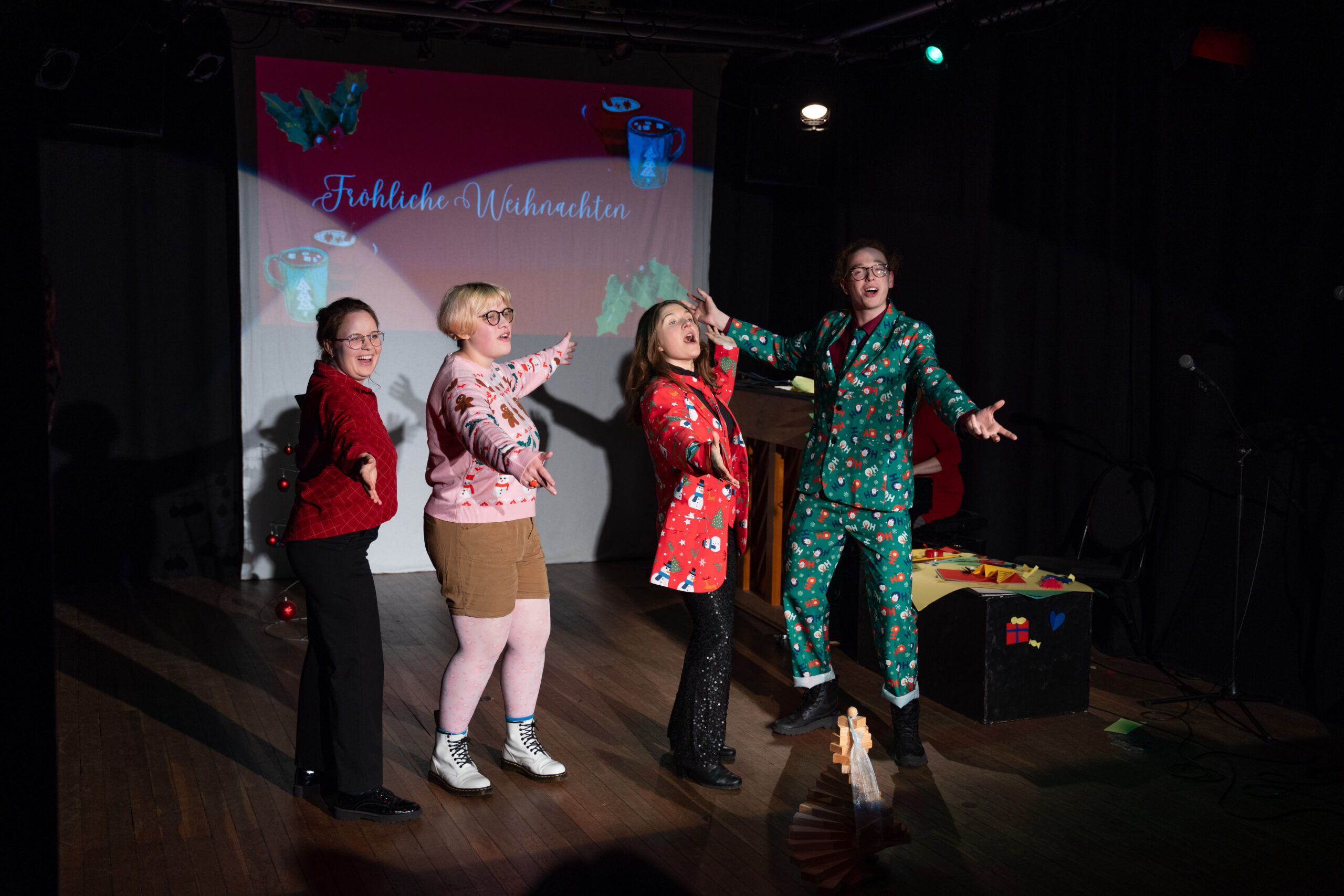 Vier Verrückte in Weihnachtspullis.