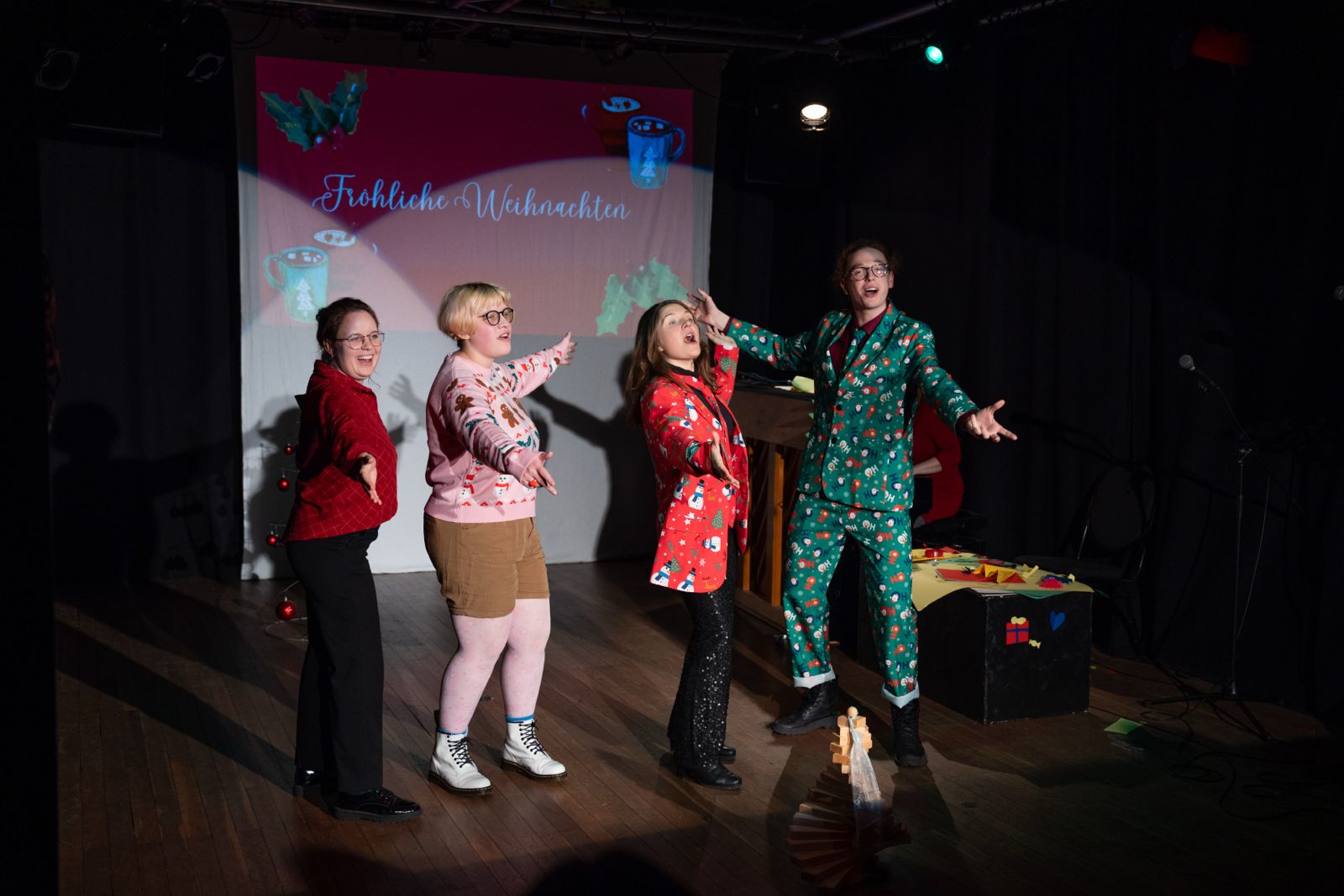 Vier Verrückte in Weihnachtspullis.