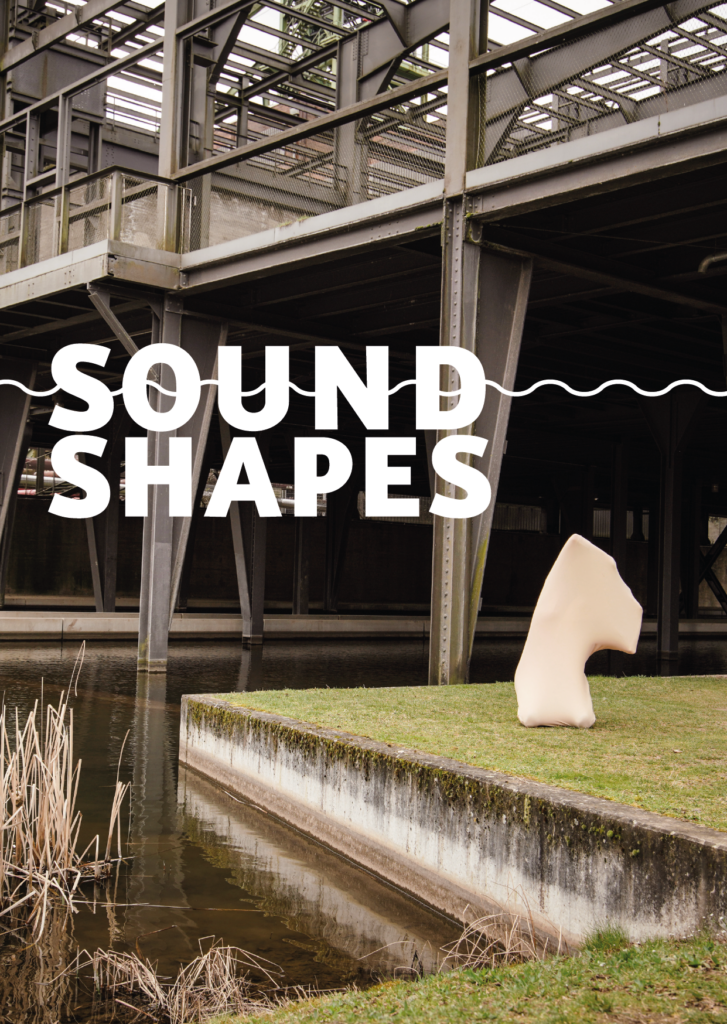 Eine vollständig in ein elastisches Tuch gehüllte Person steht unter einer Stahlkonstruktion.